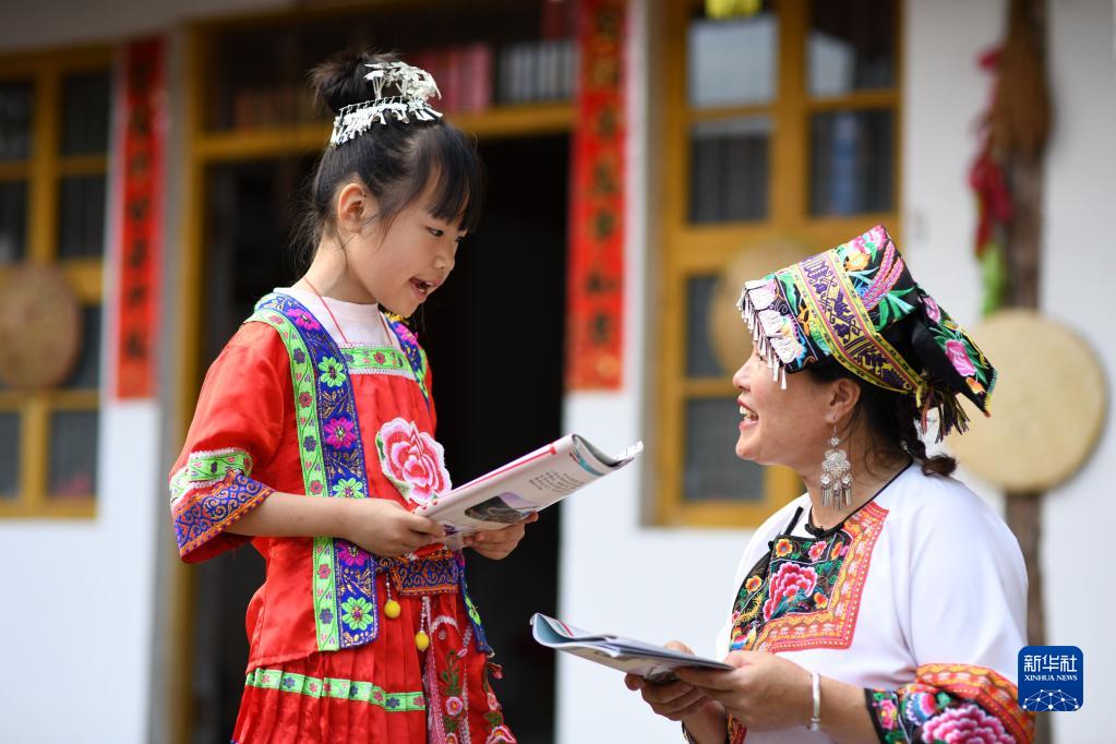 7月19日，湖南省邵陽市城步苗族自治縣長安營鎮民族文化傳播服務中心，一名小朋友在向“六月六”山歌節市級傳承人陳岩花（右）學習唱山歌。新華社發（嚴欽龍攝）