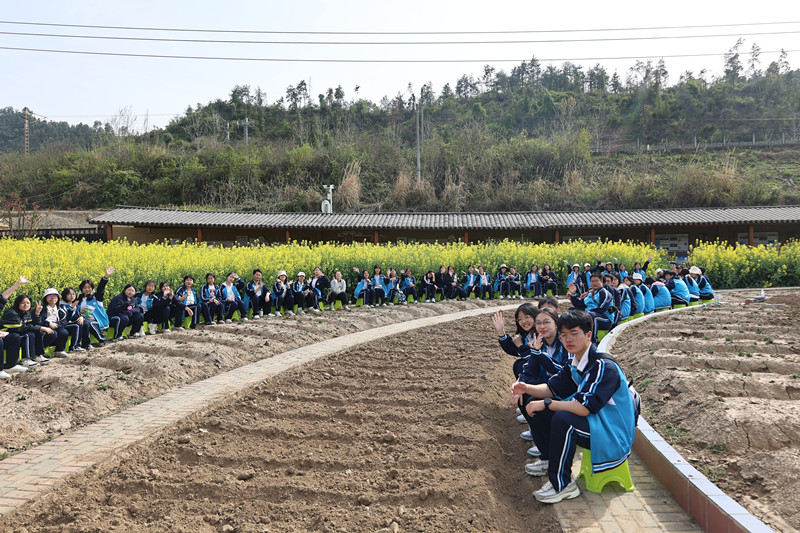 同学们在田间地头合影留念。校方供图