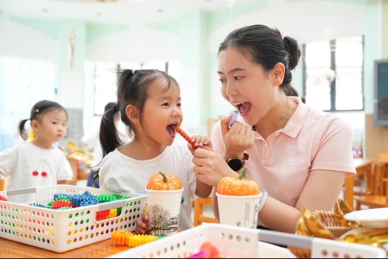 四川省直属机关实验婴儿园教师和幼儿一起做游戏。园方供图