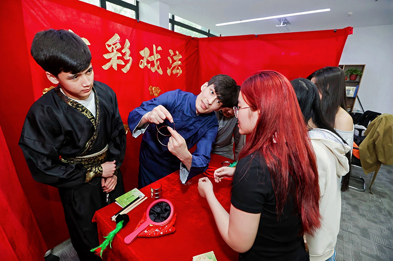留学生学习古彩戏法的玩法。校方供图