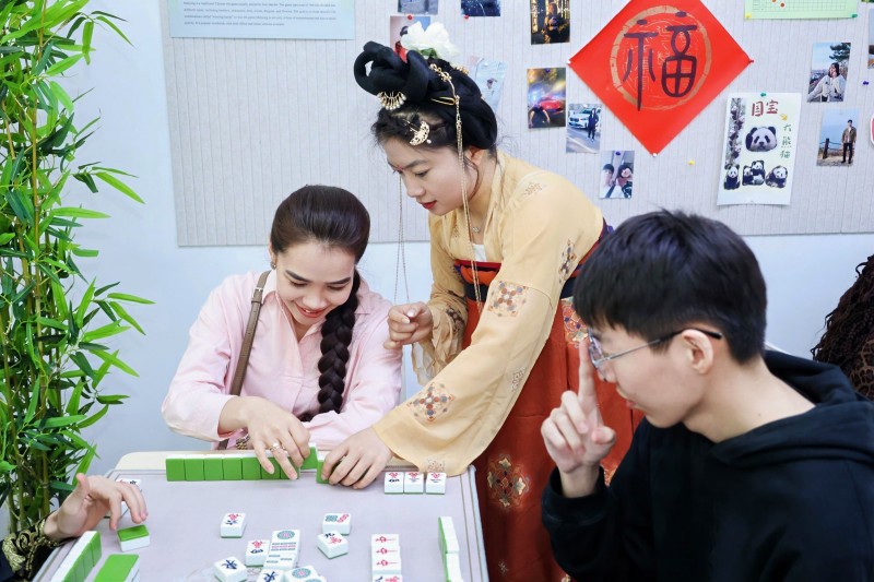 留学生学习中国麻将的玩法。校方供图